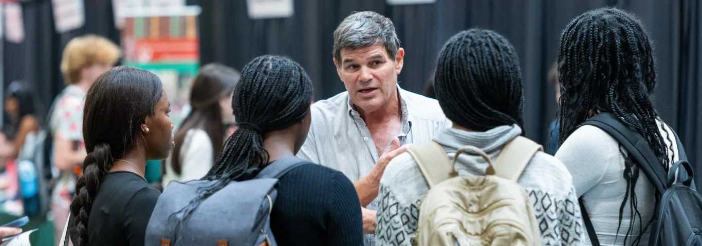 Prof Kidder talking to a group of students who are facing away from the camera. Photo Credit: Sean Garcia