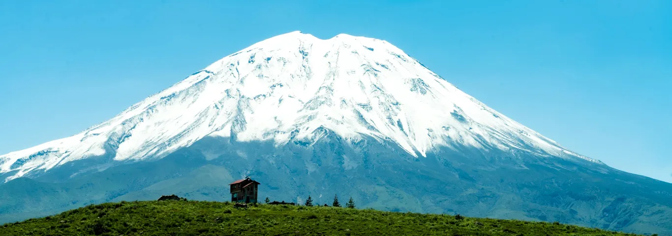Landscape of a Grass Field and a Snowcapped Volcano under Blue Sky, Peru