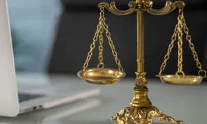 law scales with a laptop in the background
