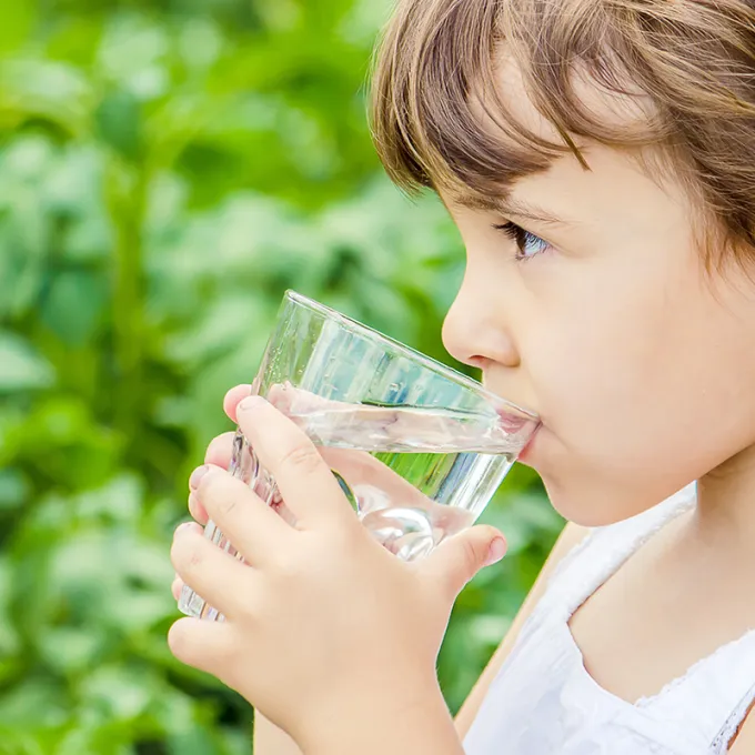 child drinking a glass of water