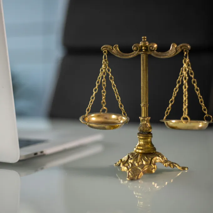 law scales with a laptop in the background