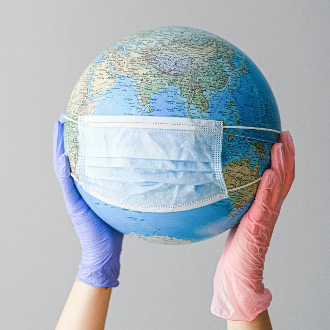 a humorous picture of a globe wearing a medical mask
